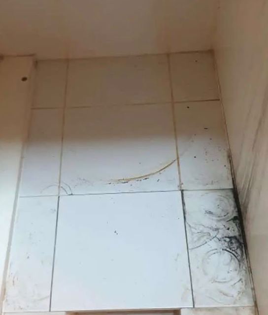 Stained tiles under the sink before cleaning